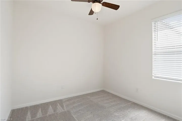Spare room featuring carpet floors and ceiling fan