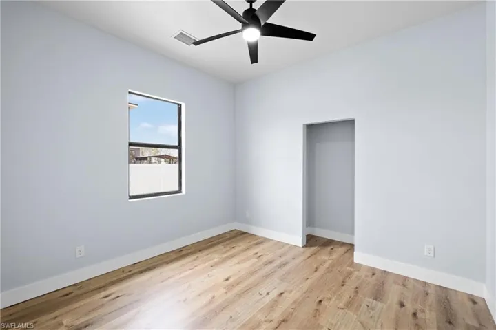 Unfurnished bedroom featuring light wood-style flooring, a ceiling fan, and a closet