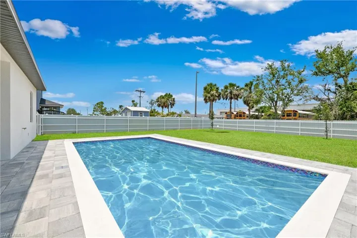 View of swimming pool with a patio area and a fenced backyard