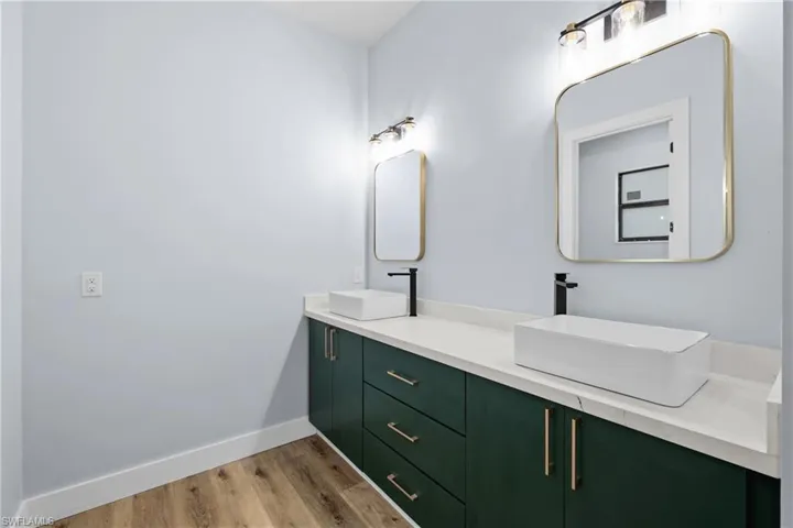 Full bath featuring light wood-type flooring and double vanity