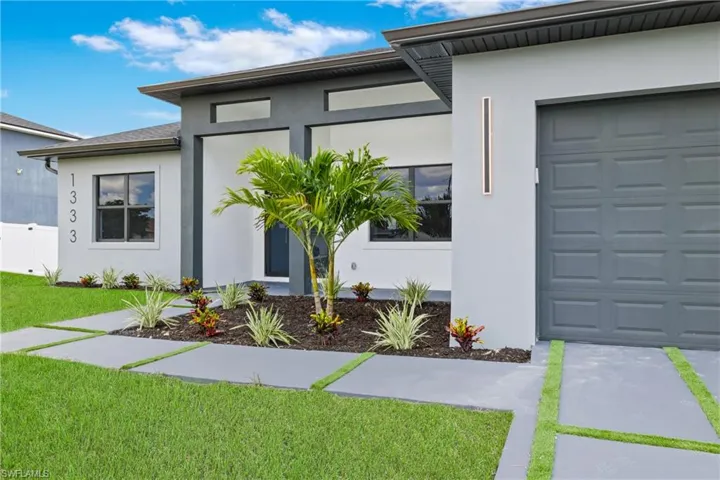 Doorway to property with stucco siding and a yard