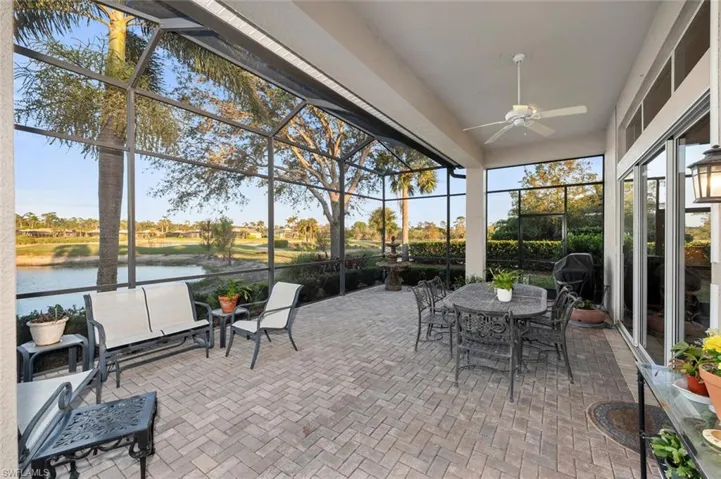 Sunroom with ceiling fan and a water view