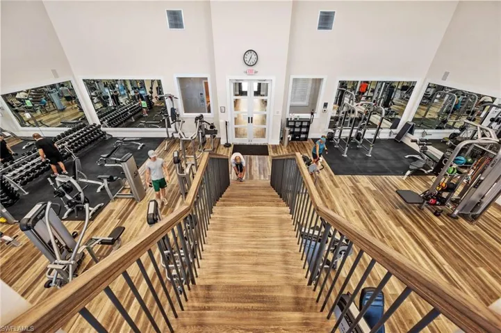 Gym with a towering ceiling and hardwood / wood-style flooring