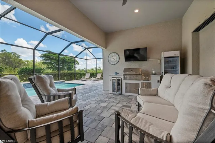 View of patio with an outdoor living space, an outdoor kitchen, a lanai, and grilling area