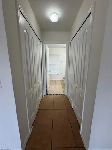 Hall featuring tile patterned floors and baseboards