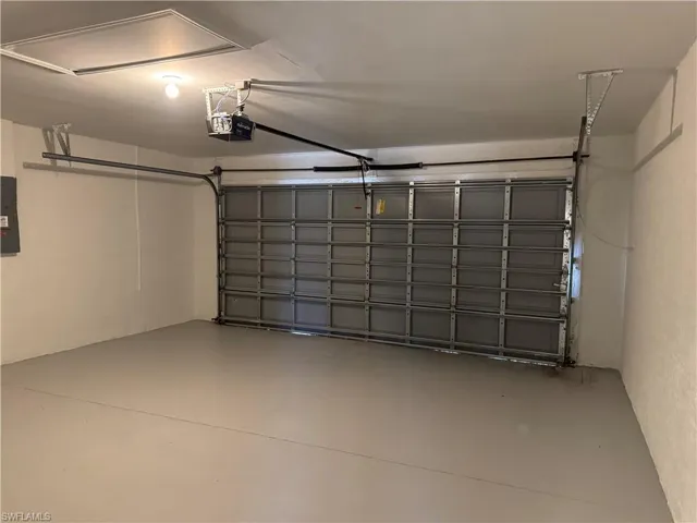 Garage featuring a garage door opener and electric panel