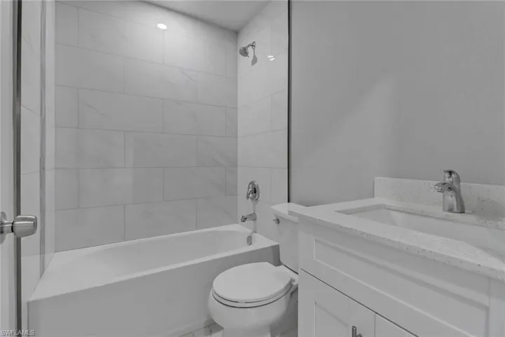 Full bathroom featuring vanity, toilet, and tiled shower / bath