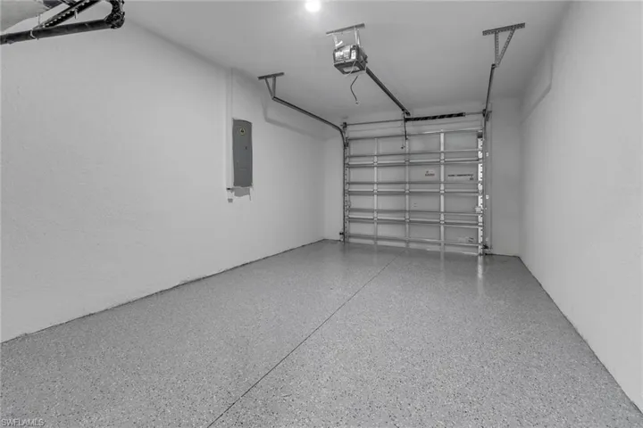 Garage featuring a garage door opener and electric panel