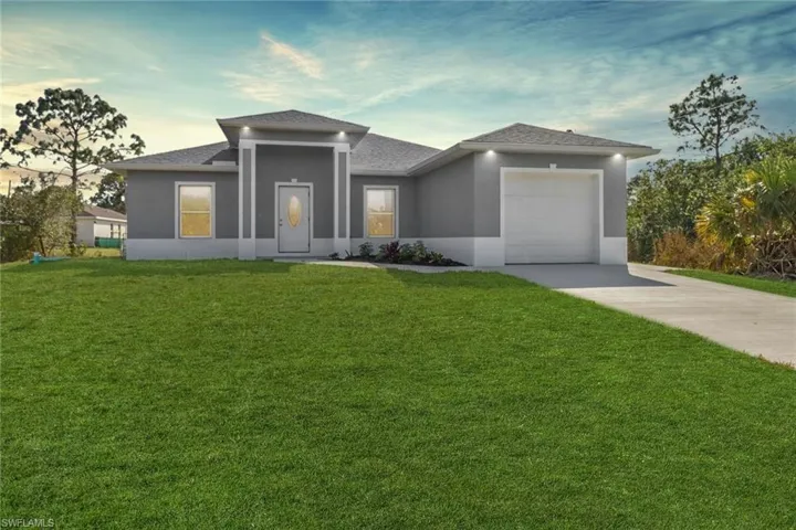 Prairie-style home with a garage and a lawn