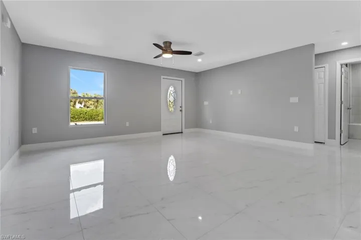 Unfurnished living room featuring ceiling fan