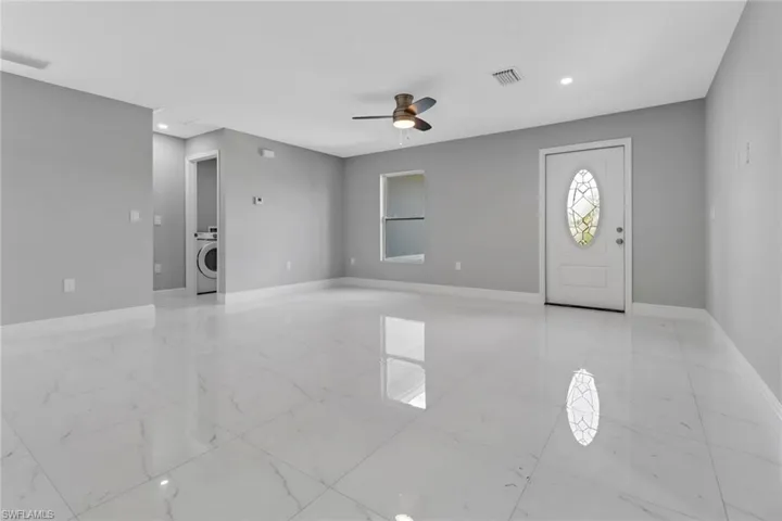 Foyer entrance with washer / dryer and ceiling fan