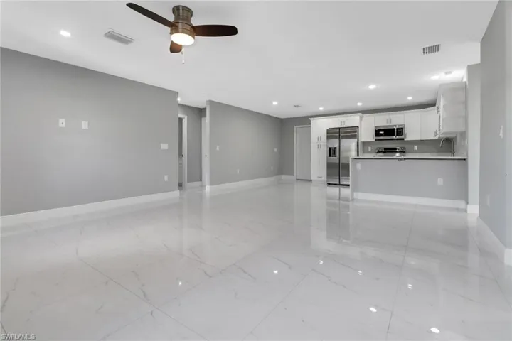 Unfurnished living room with sink and ceiling fan