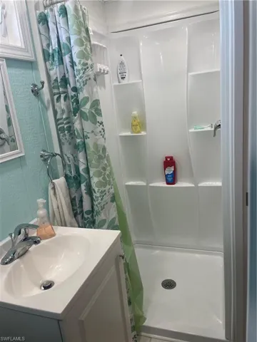 Bathroom featuring vanity and curtained shower