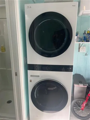 Washroom with stacked washer and clothes dryer