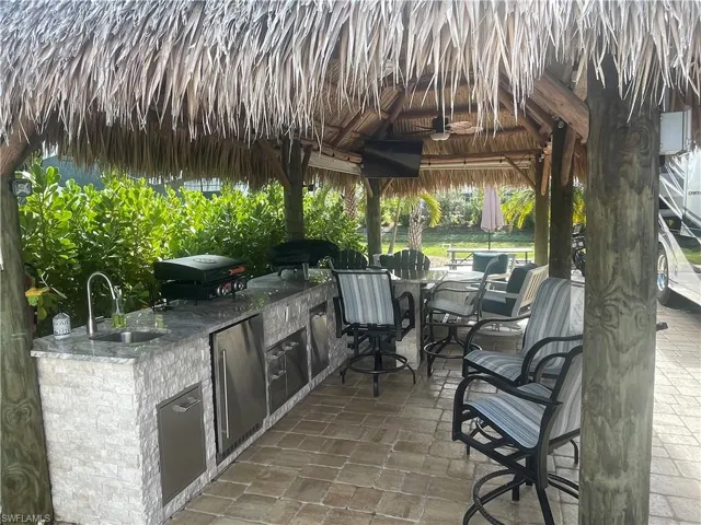 View of patio / terrace with a gazebo, area for grilling, a grill, and sink
