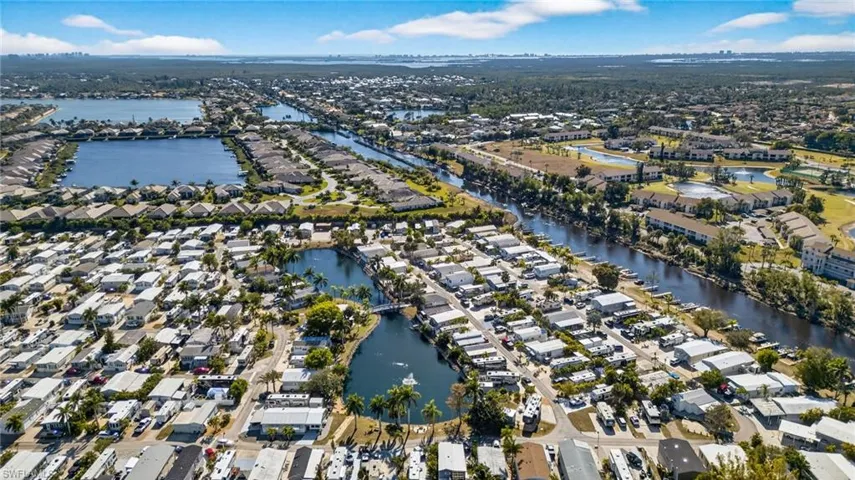 Aerial view of property and surrounding area with nearby suburban area and a large body of water