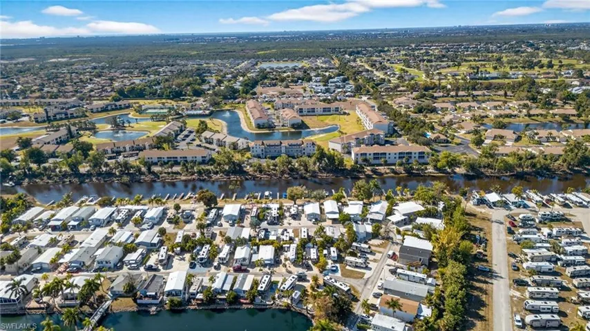 Aerial view of property and surrounding area featuring a large body of water and nearby suburban area