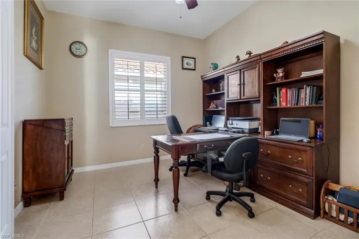 Office space with light tile patterned flooring and ceiling fan