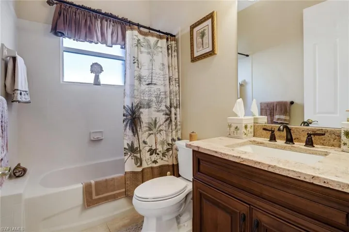 Full bathroom with shower / tub combo, tile patterned flooring, toilet, and vanity