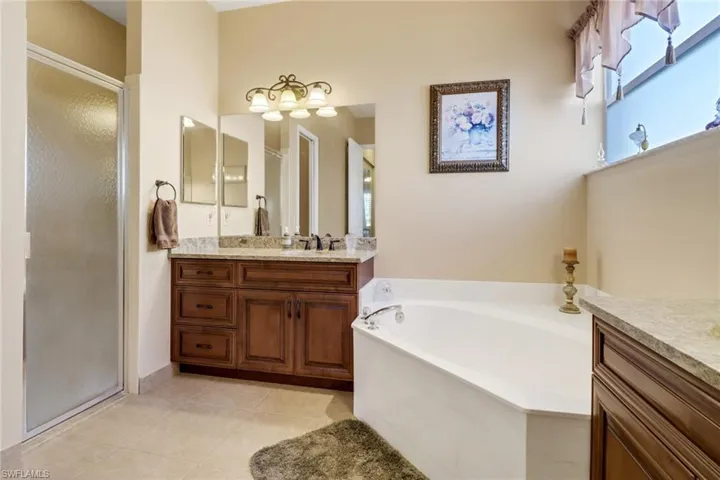 Bathroom with vanity, tile patterned flooring, and separate shower and tub