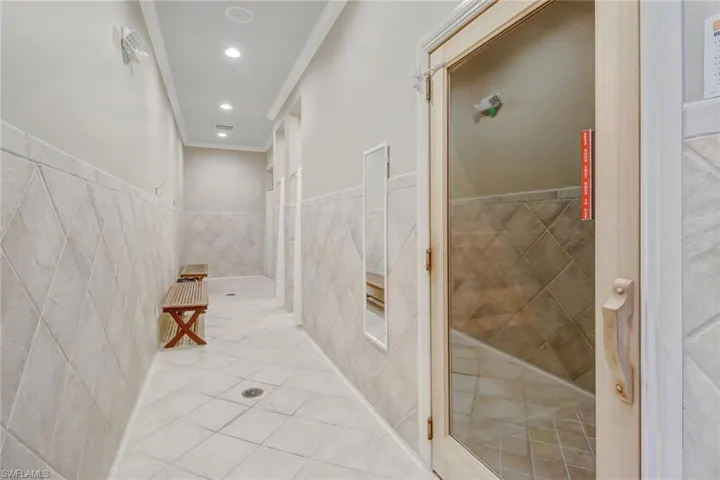Bathroom featuring crown molding and tile walls