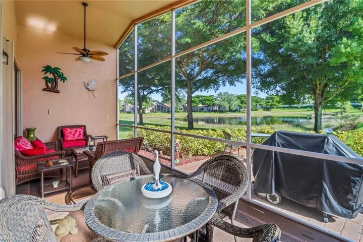 Sunroom featuring lofted ceiling, a water view, and ceiling fan
