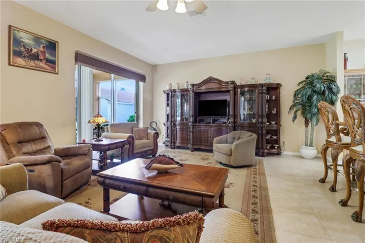 Tiled living room featuring ceiling fan and plenty of natural light