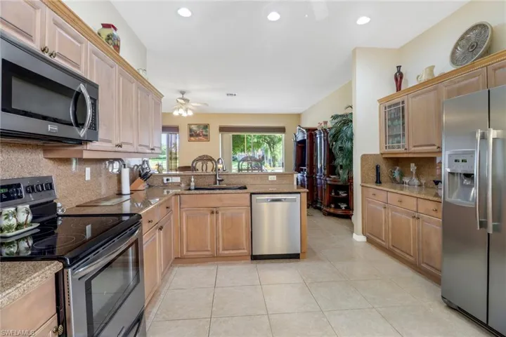 Kitchen with ceiling fan, tasteful backsplash, appliances with stainless steel finishes, and kitchen peninsula