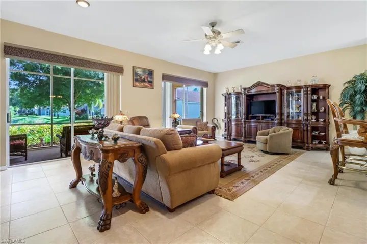 Living room with ceiling fan and light tile patterned floors