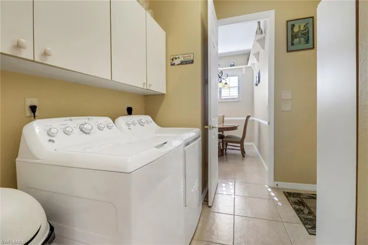 Laundry room with light tile patterned flooring and separate washer and dryer