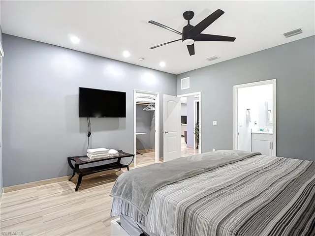 Bedroom with a walk in closet, light wood-type flooring, a ceiling fan, and recessed lighting
