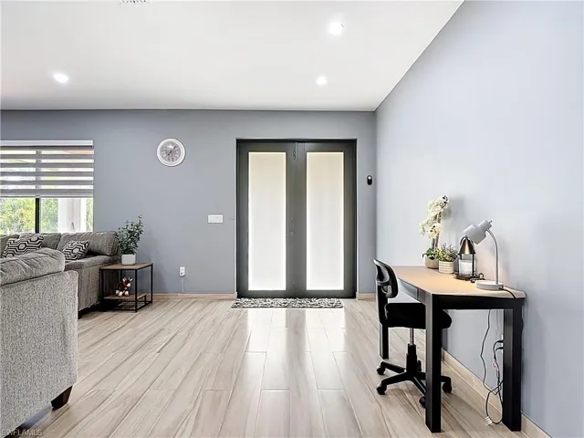 Office with french doors, light wood-style floors, and recessed lighting