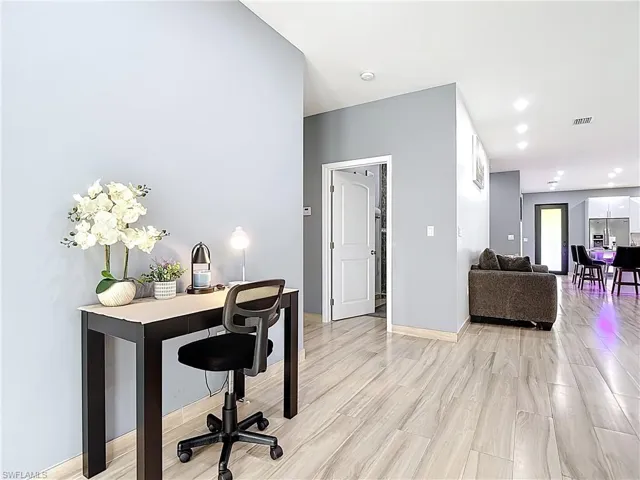 Office space with light wood-style flooring and recessed lighting