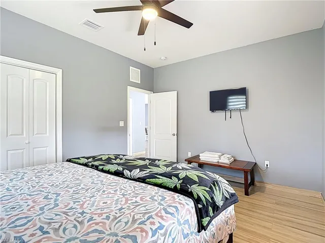 Bedroom with light wood-type flooring, a closet, and ceiling fan