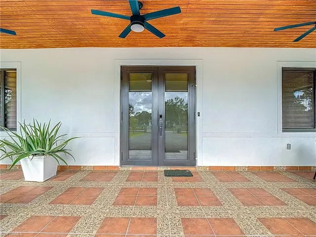 View of exterior entry featuring a ceiling fan and stucco siding