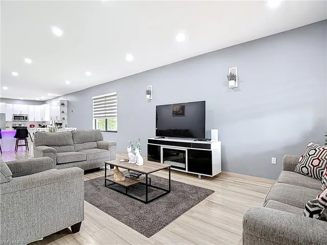 Living room with recessed lighting and light wood-type flooring