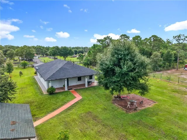 Aerial view of property and surrounding area with a tree filled landscape
