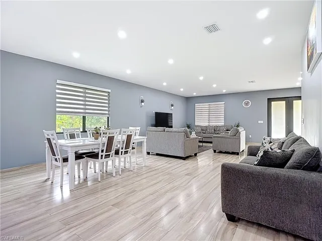 Living room with recessed lighting and light wood-type flooring