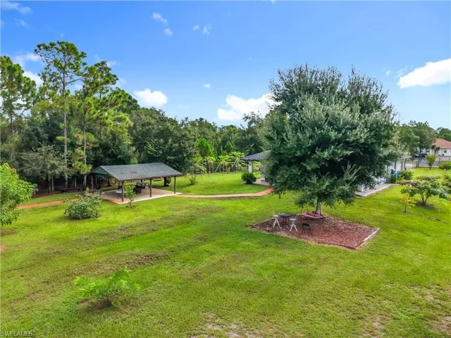 View of grassy yard featuring a patio and a carport