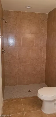 Bathroom featuring a shower stall, tile patterned floors, and recessed lighting