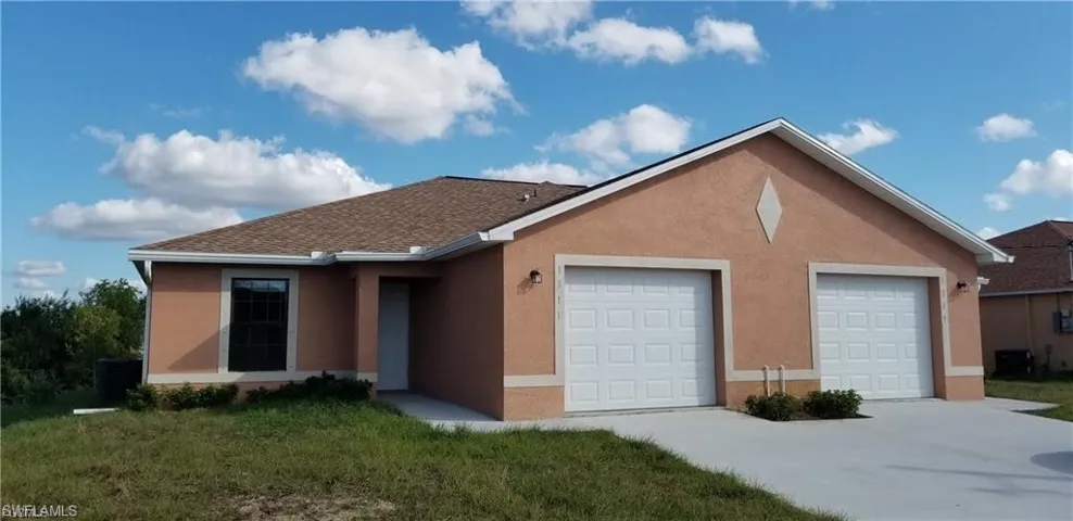 Single story home with an attached garage, stucco siding, a front lawn, and driveway