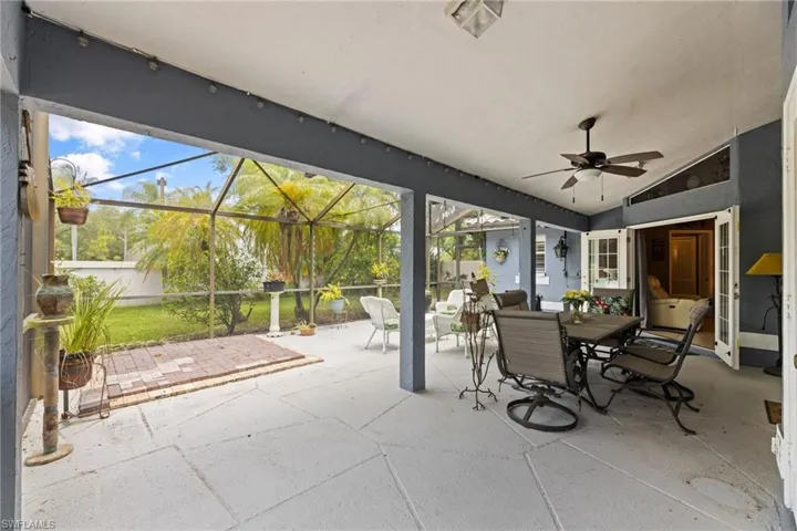 View of patio with outdoor dining space, a lanai, and a ceiling fan