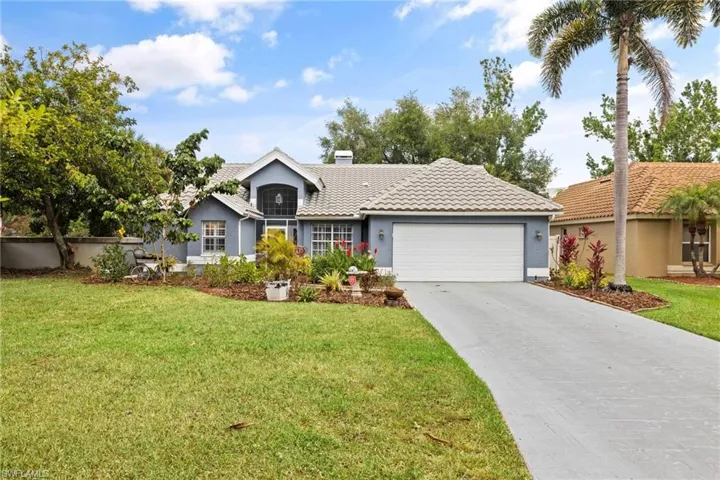 Ranch-style home featuring stucco siding, a front lawn, driveway, a garage, and a tiled roof
