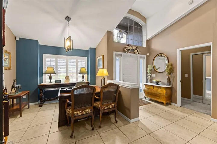 Dining area with a high ceiling, light tile patterned floors, baseboards, and a wealth of natural light