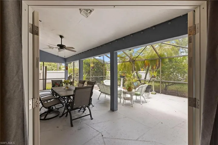 Unfurnished sunroom with outdoor dining area and ceiling fan