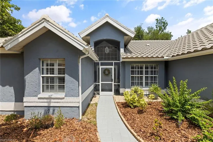 Property entrance featuring stucco siding and a tile roof