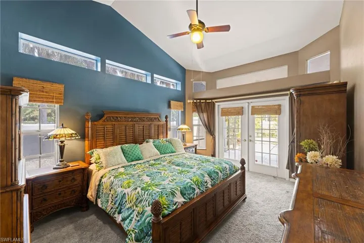 Carpeted bedroom with access to exterior, visible vents, french doors, high vaulted ceiling, and a ceiling fan