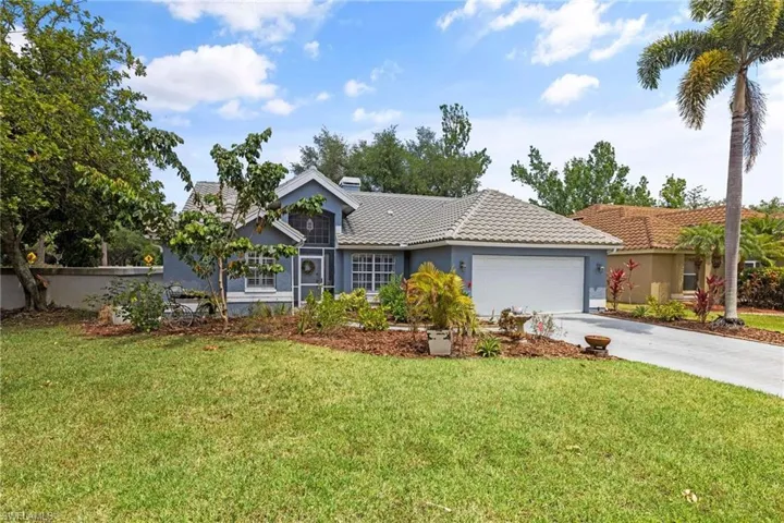 Ranch-style house featuring a garage, concrete driveway, a front yard, and stucco siding