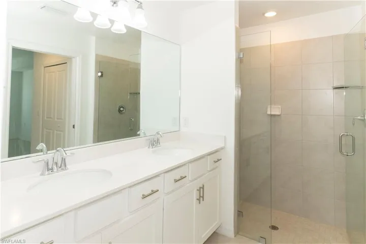 Bathroom featuring vanity and a shower with door