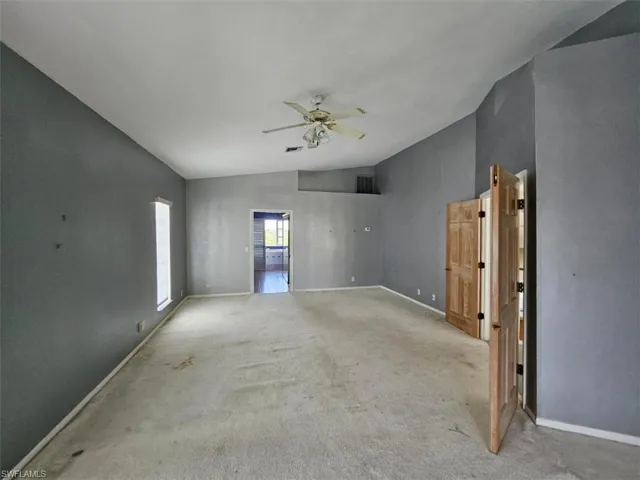 Unfurnished room with carpet, ceiling fan, and lofted ceiling